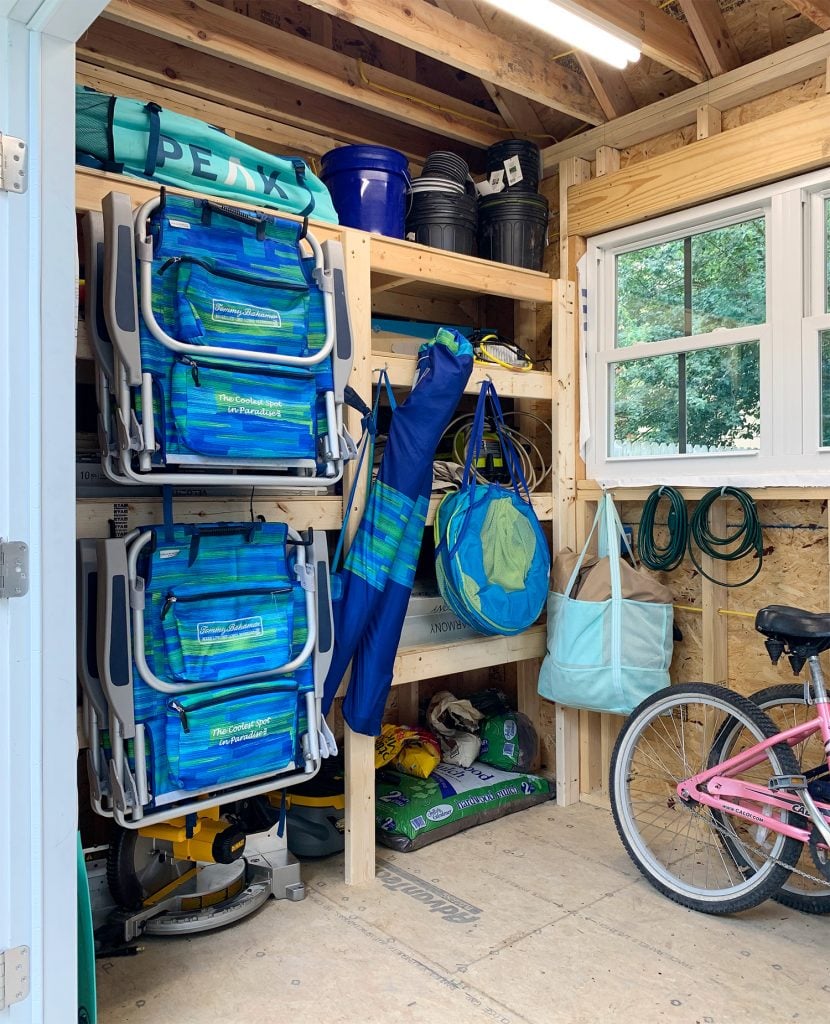 beach-shed-organization-shelves-with-beach-stuff-830x1024-1 Heavy duty shelves for beach house shed with beach chairs hung on front