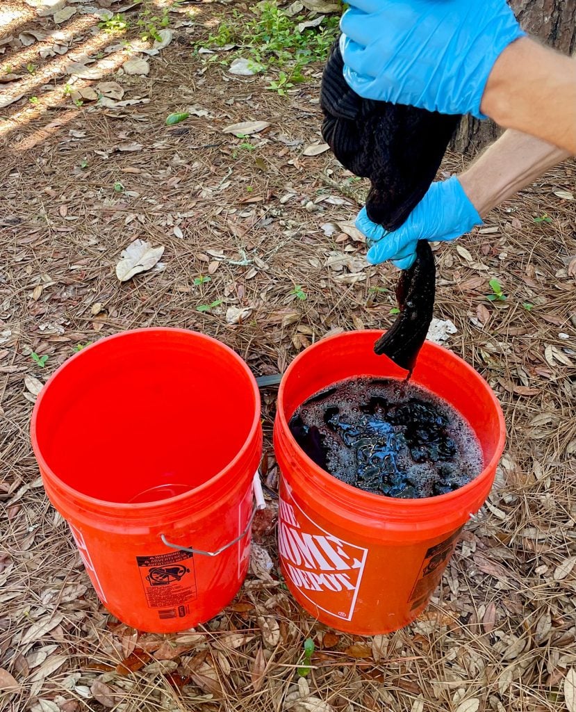 dye-clothes-squeezing-out-dye-829x1024-1 Squeezing Out Excess Fabric Dye From Black Sweater Over Bucket