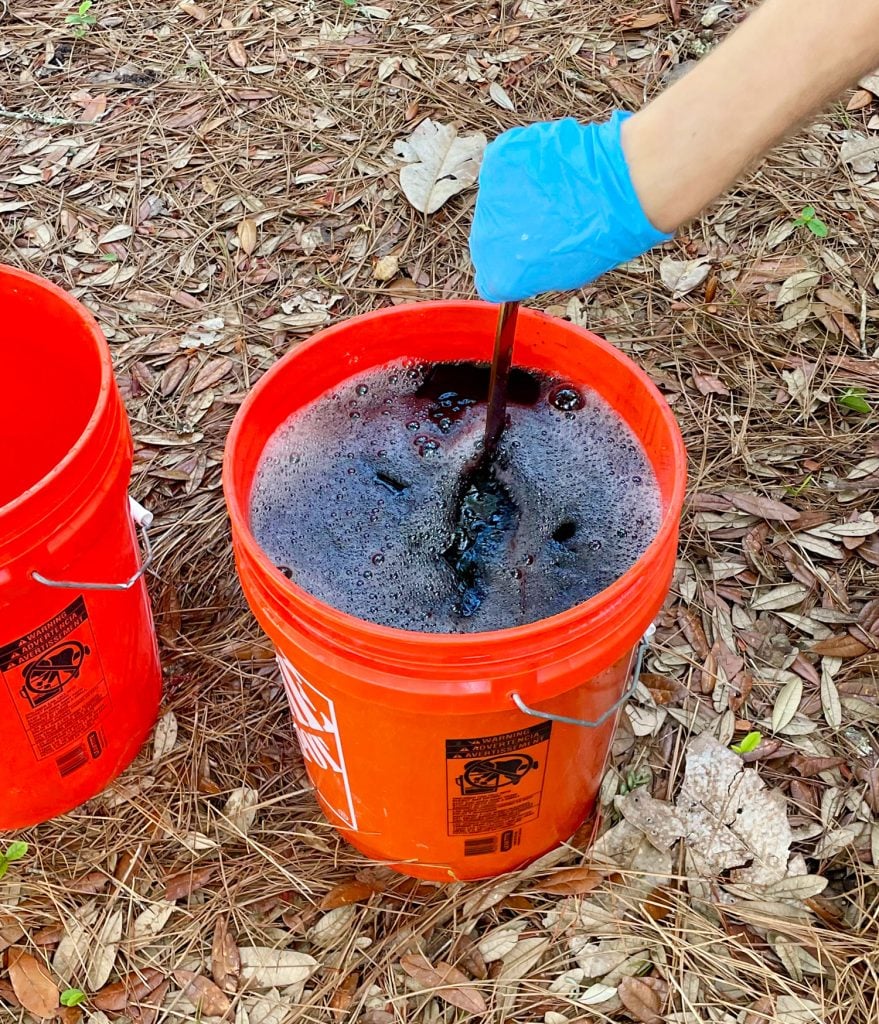 dye-clothes-stirring-with-stir-stick-879x1024-1 Hand Stirring Bucket Of Black Rit Fabric Dye With Clothes Inside