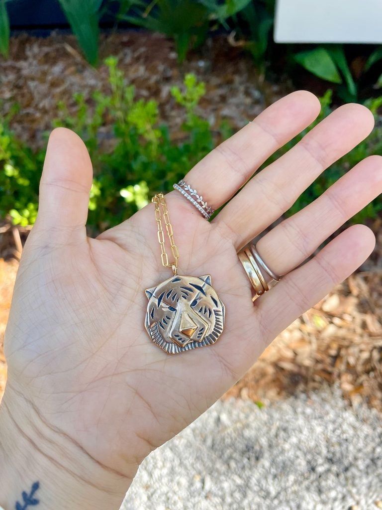 ocean-springs-palemtte-tiger-necklace-768x1024-1 Sherry Hand Holding Gold Tiger Necklace Purchased at Palmette In Ocean Springs Mississippi