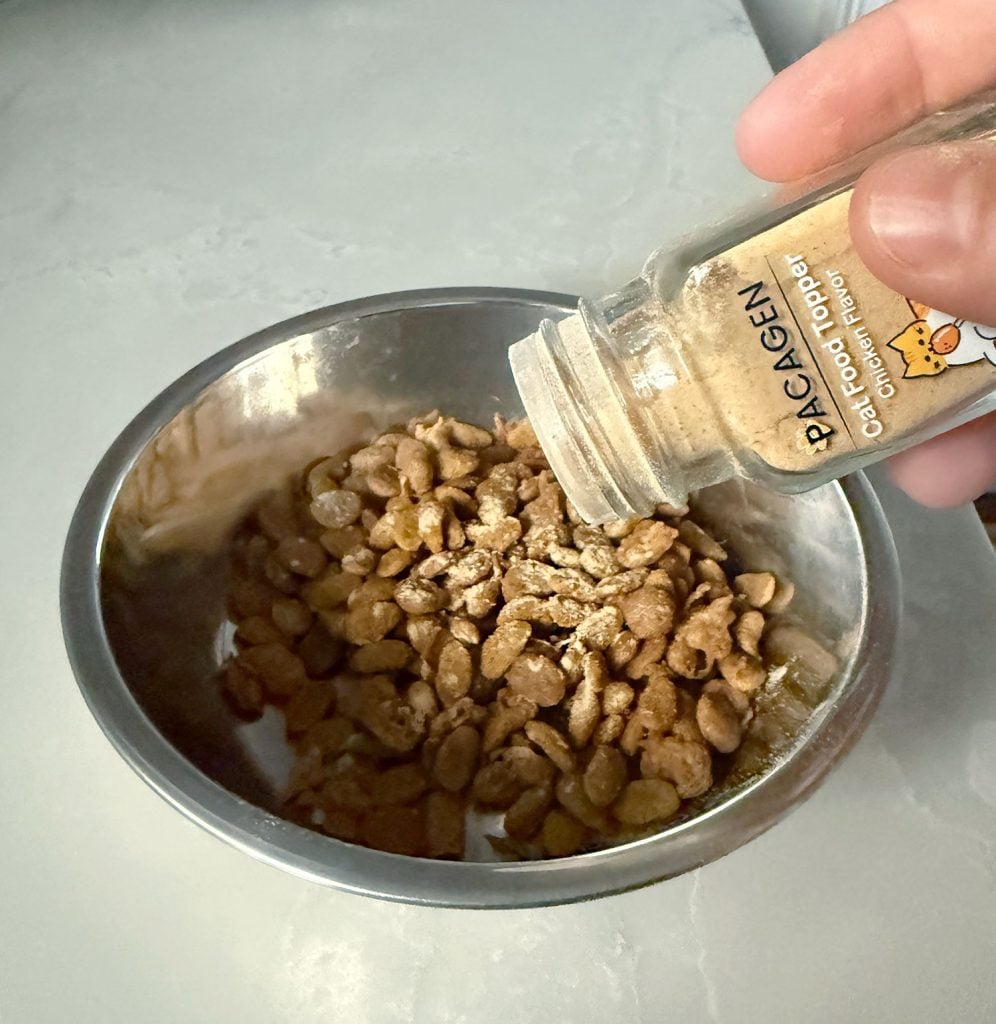 shaking-pacagen-cat-foood-topper-on-cat-food-996x1024-1 Shaking Pacagen Cat Food Topper on Dry Cat Food