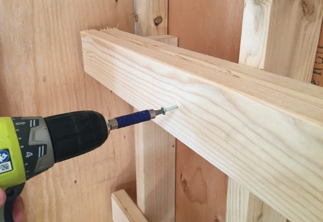 shed-storage-wood-shelves-screw-second-boards-up-650x447-1 screwing in horizontal support for DIY garage shelf