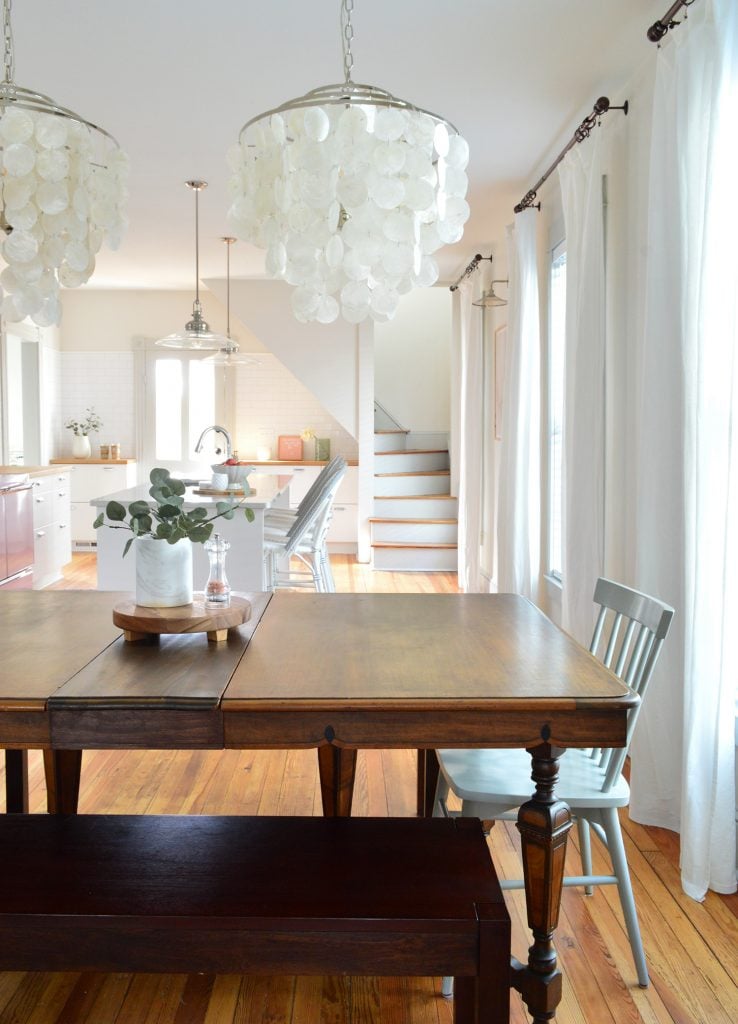 beach-house-dining-room-new-chandeliers-to-kitchen-vertical-738x1024-1 Row of curtains hung in beach house dining room using dark bronze curtain rods.