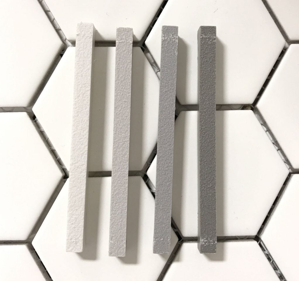 best-grout-mapei-test-against-hex-tile-1024x960-1 four mapei grout sample sticks atop white hex tile going from light to dark