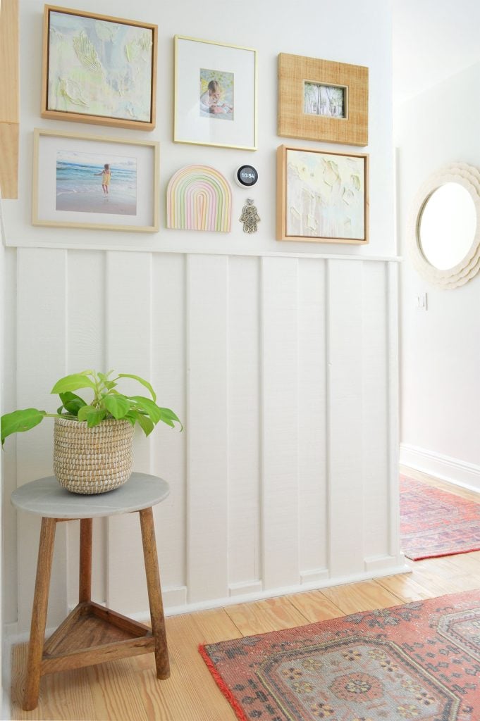 downsized-items-hallway-planter-681x1024-2 White hallway with wainscoting and picture frame collage and turkish runner rugs