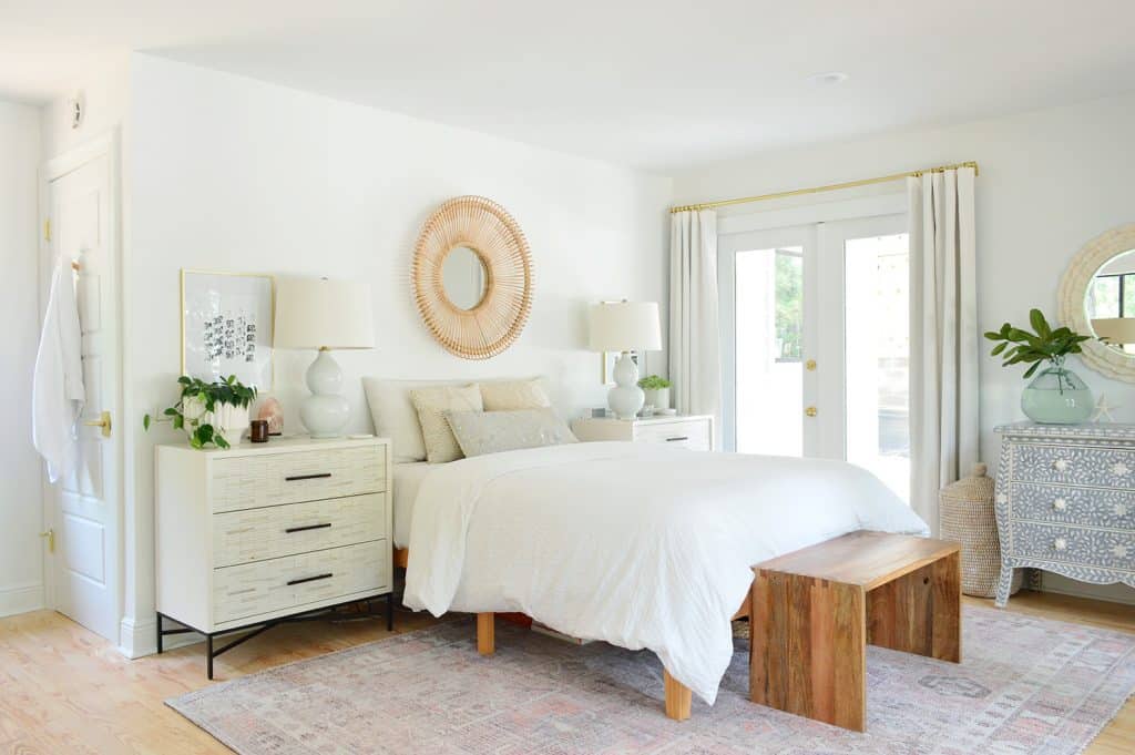 florida-our-bedroom-bed-full-with-door-1024x681-1 Florida bedroom with white walls and bedding with woven accents and traditional rug