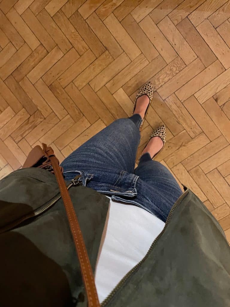 Sherry wearing white tank with green jacket and jeans with leopard print shoes