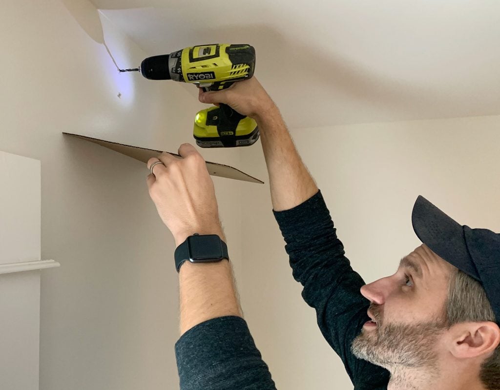hanging-curtain-rods-catching-dust-1024x799-1 Drilling larger holes for curtain rod using cardboard to catch dust