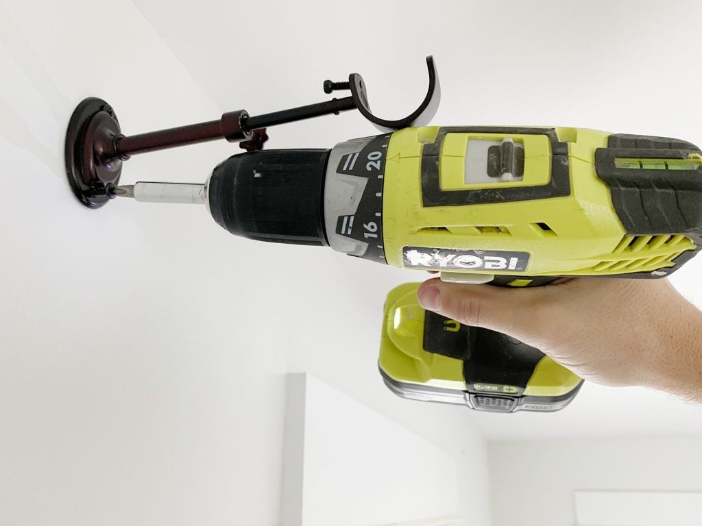 hanging-curtain-rods-screwing-in-1024x768-1 Attaching curtain rod hook using power drill