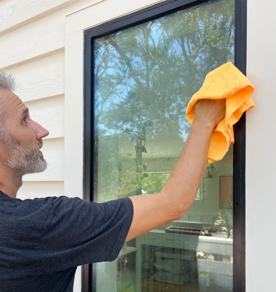 homemade-glass-cleaner-john-wiping-window-967x1024-1 John Washing Window With Homemade Glass Cleaner and Microfiber Cloth