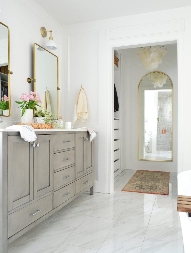 marble-master-bathroom-vanity-and-closet-vertical-774x1024-1 Marlbe bathroom with gray double vanity and doorway into walk in closet