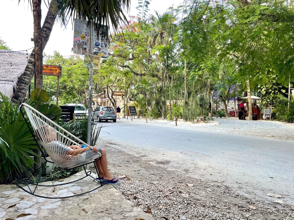 mexico-with-kids-tulum-beach-road-1024x768-1 Kid sitting in rocking chair near road in Tulum Mexico