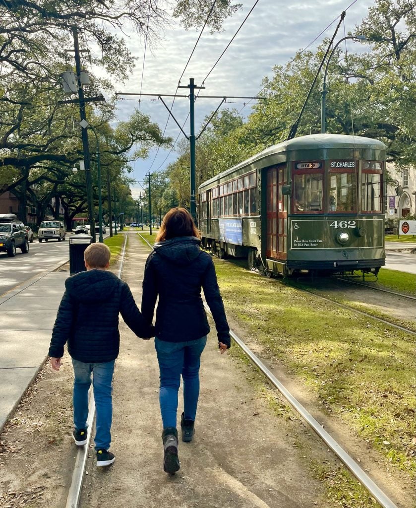 new-orleans-kid-walking-near-streetcar-839x1024-1 Mom And Child Walking Near New Orleans Street Car