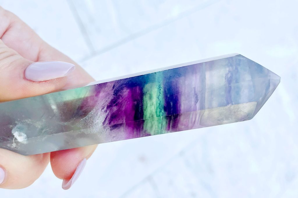 rainbow-fluorite-colorful-banding-detail-1024x681-1 Hand holding crystal with purple green rainbow banding