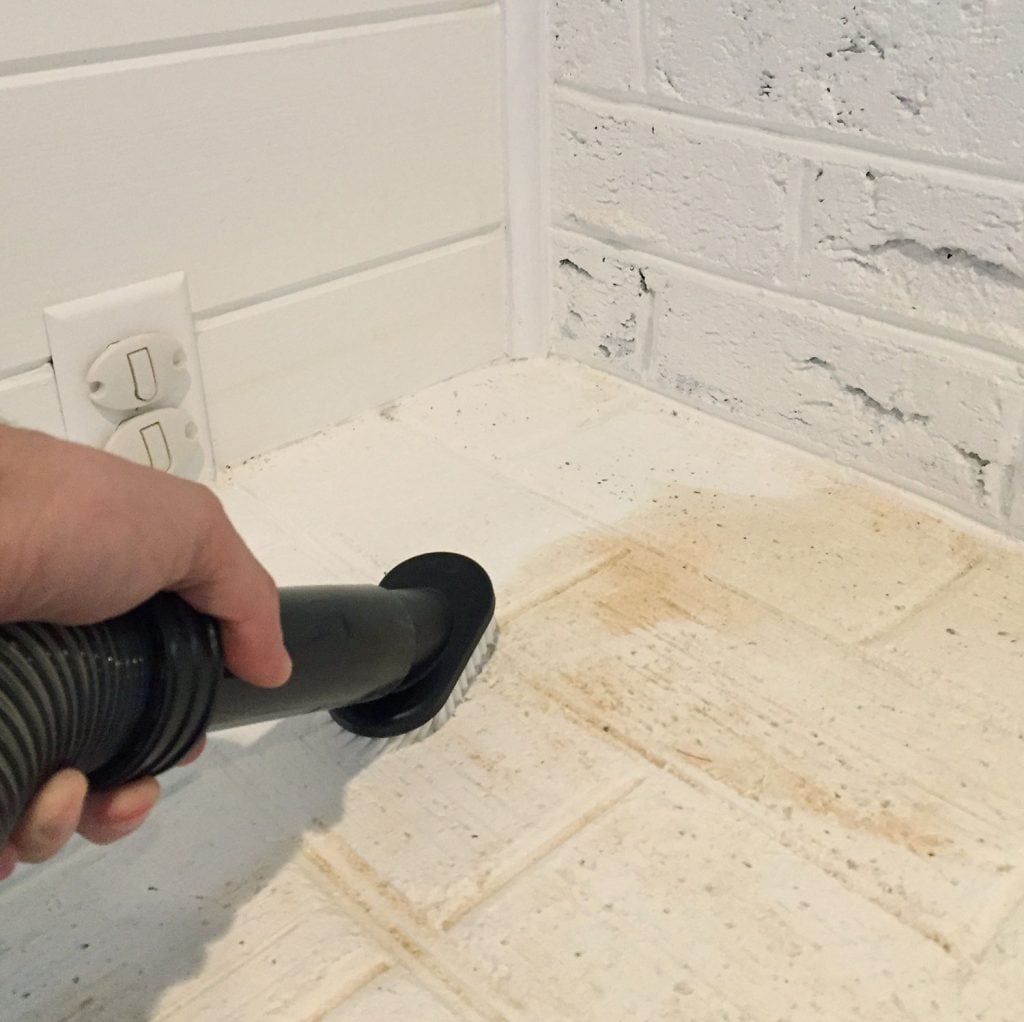 Vacuuming up sanding dust from hardwood floor refinishing project
