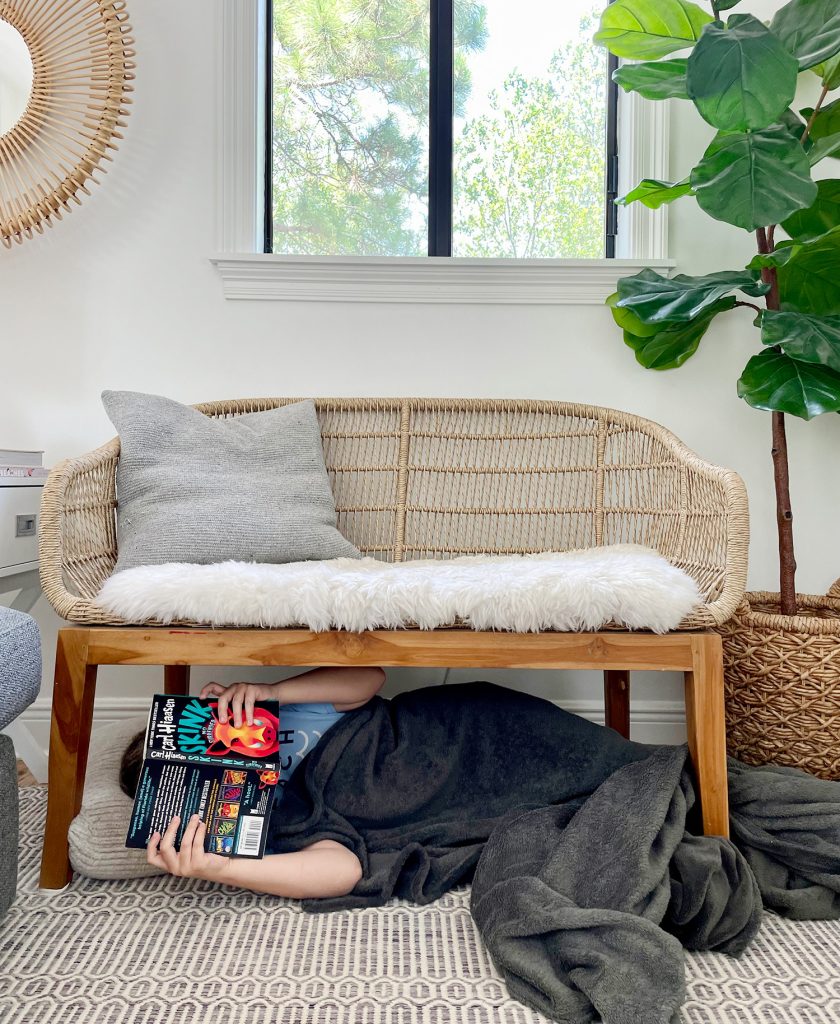 summer-readin-bracket-boy-under-bench-840x1024-1 Kid Reading Under A Bench In Living Room With Blanket