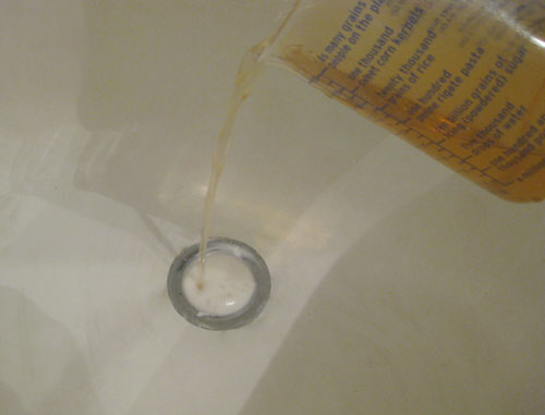 unclogging-a-drain-baking-s pouring vinegar and baking soda in clogged bathroom drain