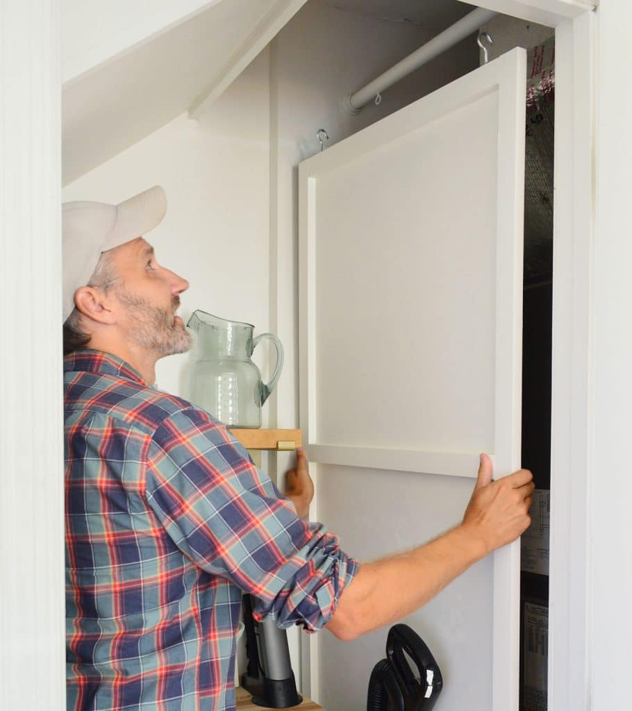 utility-closet-hvac-hidden-panel-john-lifting-910x1024-1 John Lifting HVAC Cover Panel Off Of Hanging Rod