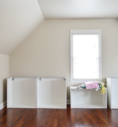 bonusbuilts-lowers-cabsbuiltdollbed Room with sloped ceiling and Ikea cabinet boxes being built, with a girl's doll using one as a window seat