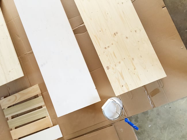bonusbuilts-lowers-counterpainting Wood project panels from Lowe's being primed and painted white using a small foam roller for use as countertops