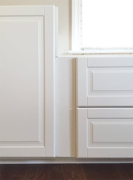bonusbuilts-lowers-uglyrecess filler piece between two white Ikea Sektion cabinets with Bodbyn doors creating recessed spot between doors and drawers