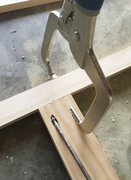 bonusbuilts-uppers-kreggingaway A Kreg jig clamp being used to secure two pieces of wood together at a right angle using a pocket hole screw
