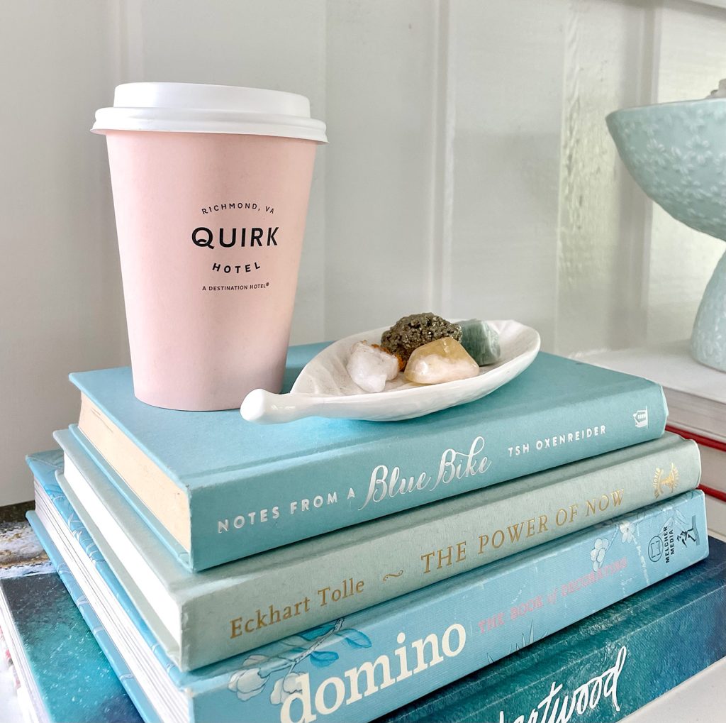 family-room-shelf-detail-quirk-cup-1024x1019-1 Close Up Of Stack of Blue Books With Pink Quirk Hotel Coffee Cup