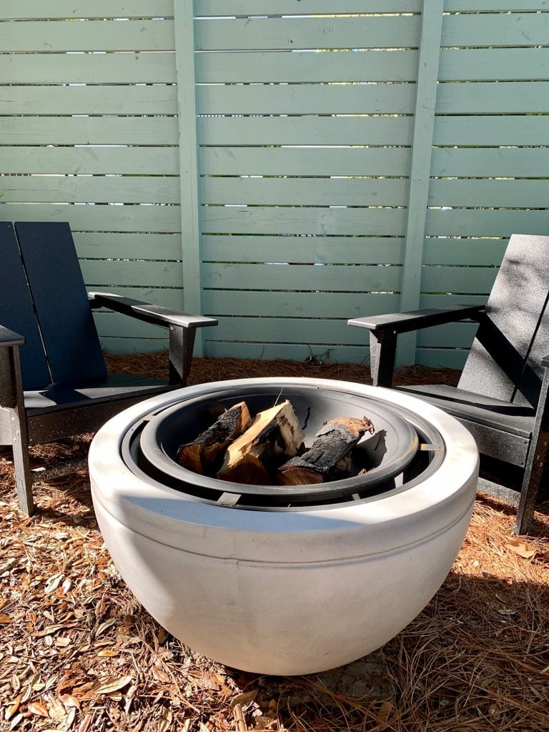 firepit-area-vertical-firepit-detail-768x1024-1 Detail of faux stone fire pit with burnt logs in it