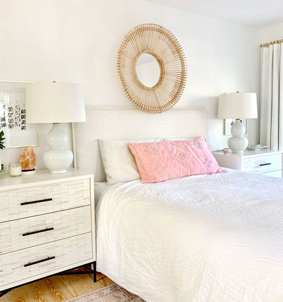fireplace-headboard-wide-shot-961x1024-1 Linen headboard on bed with white bedding and round wicker mirror over headboard