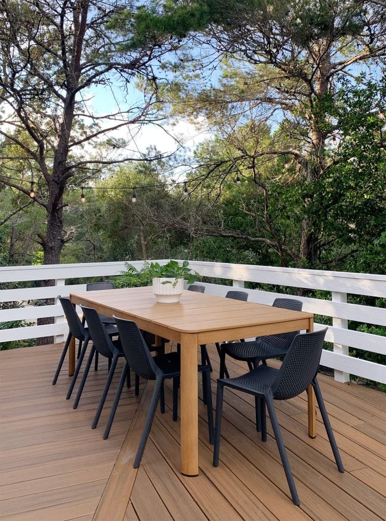 florida-deck-dining-area-vertical-759x1024-1 Faux Wood Metal Outdoor Dining Table With Black Chairs Surrounded By Trees
