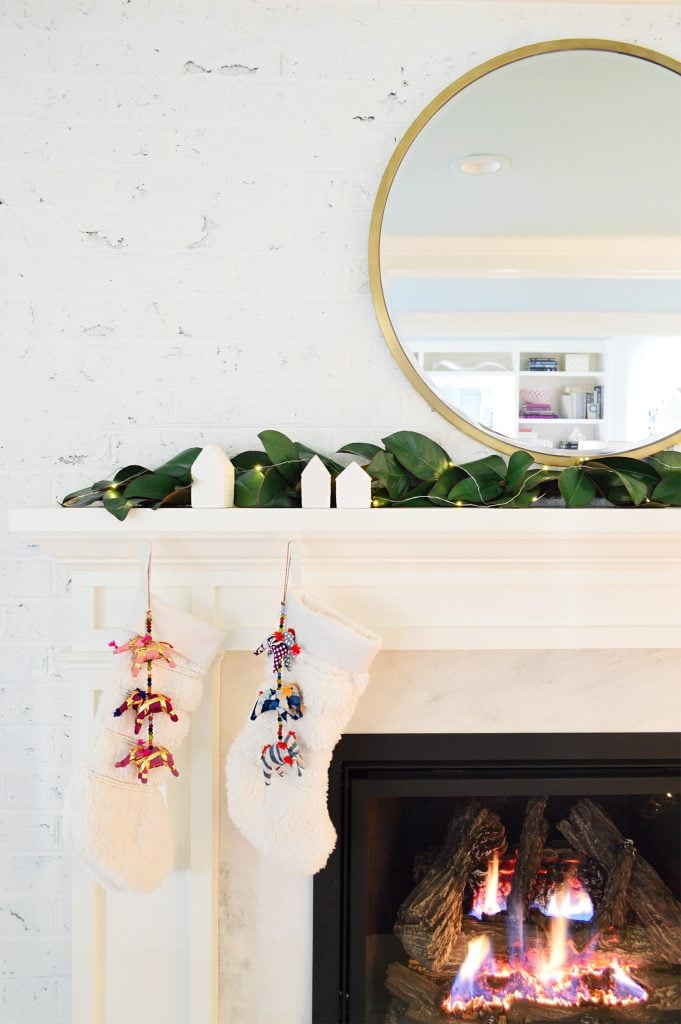 holiday-christmas-tree-fireplace-detail-681x1024-1 Detail of white traditional fireplace surround with stockings and garland