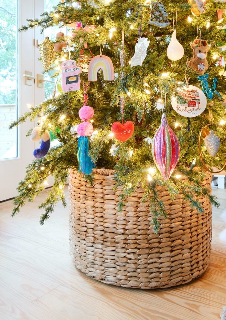 holiday-decor-2020-christmas-tree-basket-detail-722x1024-1 Woven Basket At Base Of Christmas Tree With Colorful Ornaments