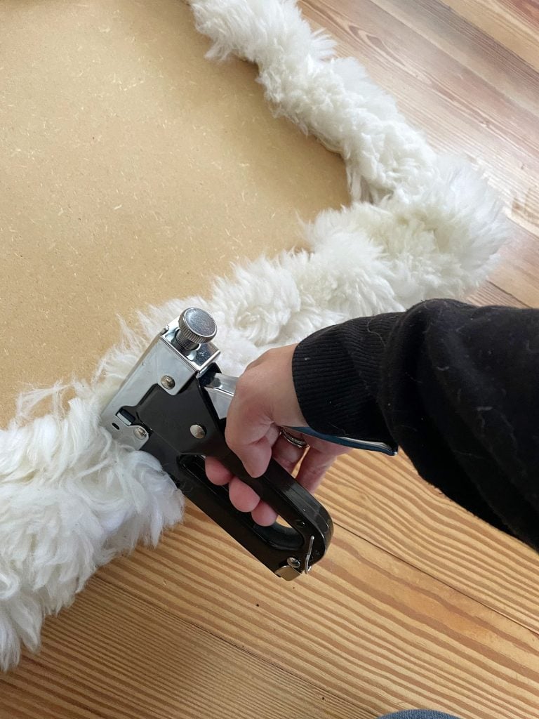 holiday-house-bench-upholstery-staple-pic-768x1024-1 Sherry stapling old sheepskin rug around loveseat base to upholster