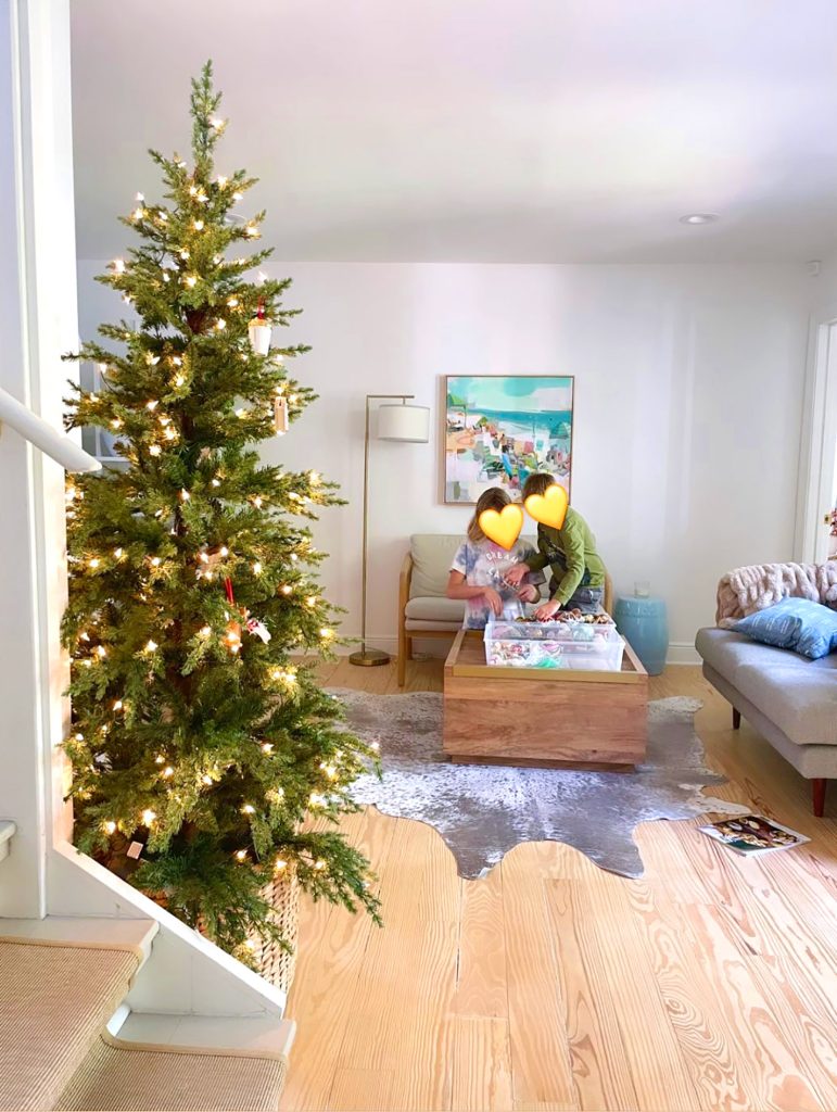 holiday-house-decorating-the-tree-771x1024-1 Christmas Tree undecorated in kitchen with children grabbing ornaments in background