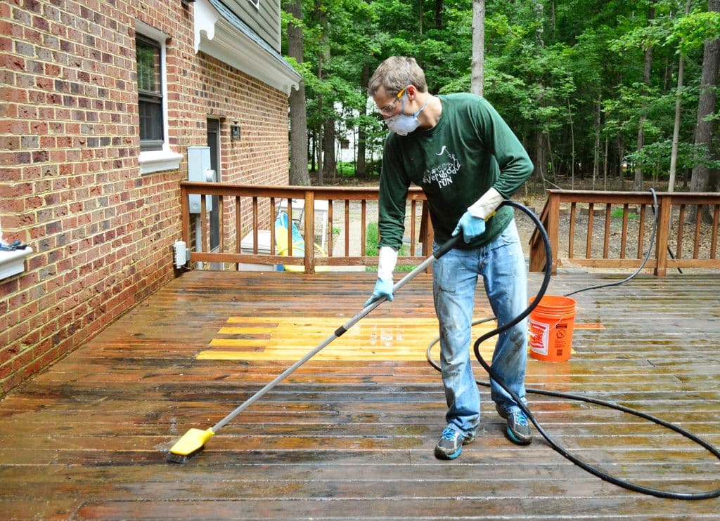 how-to-strip-a-deck-brush-with-hose-1024x742-1 John scrubbing deck with brush attached to hose