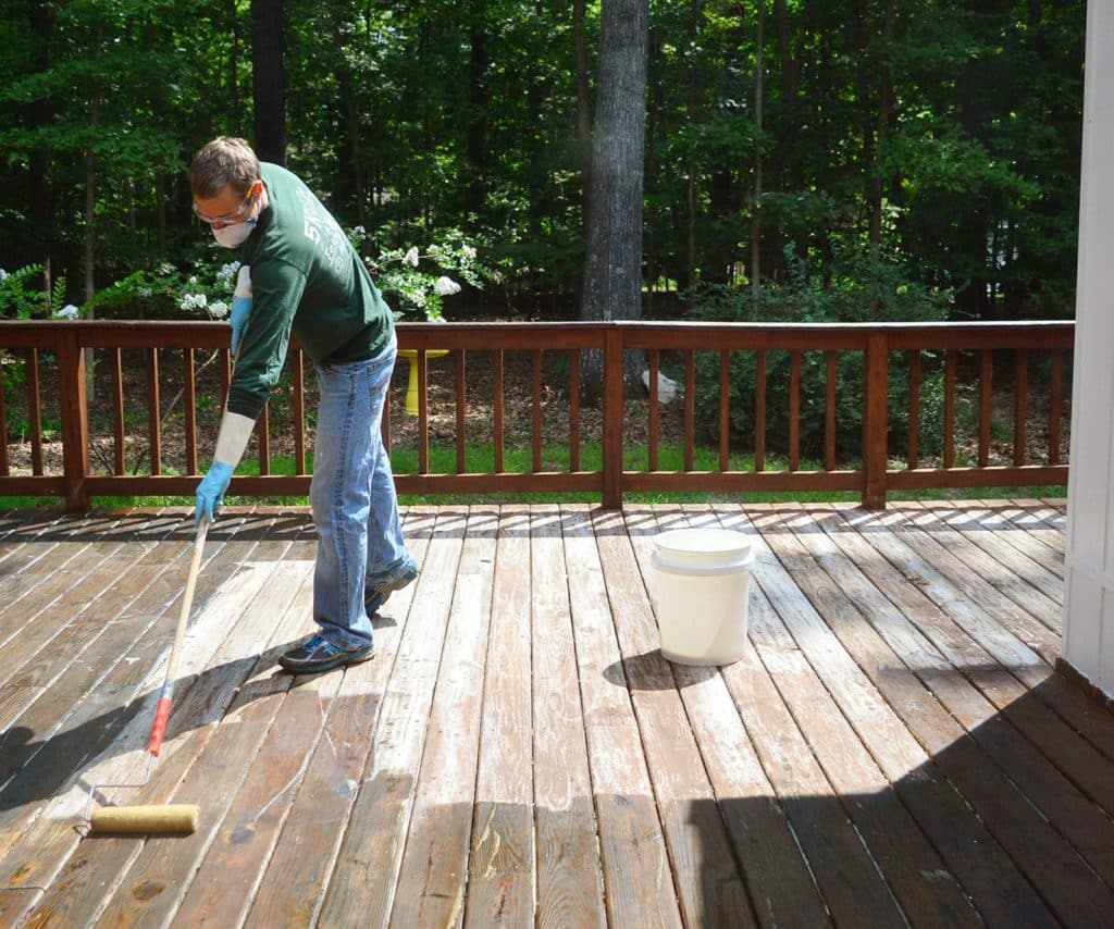 how-to-strip-a-deck-john-rolling-in-sun-1024x854-1 John applying deck stripper to wood deck in the sun