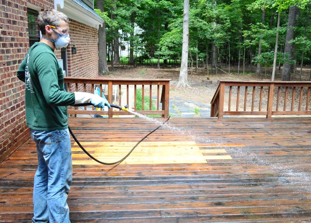 how-to-strip-a-deck-john-spraying-hose-1024x735-1 John rinsing stripper finish off of wood deck