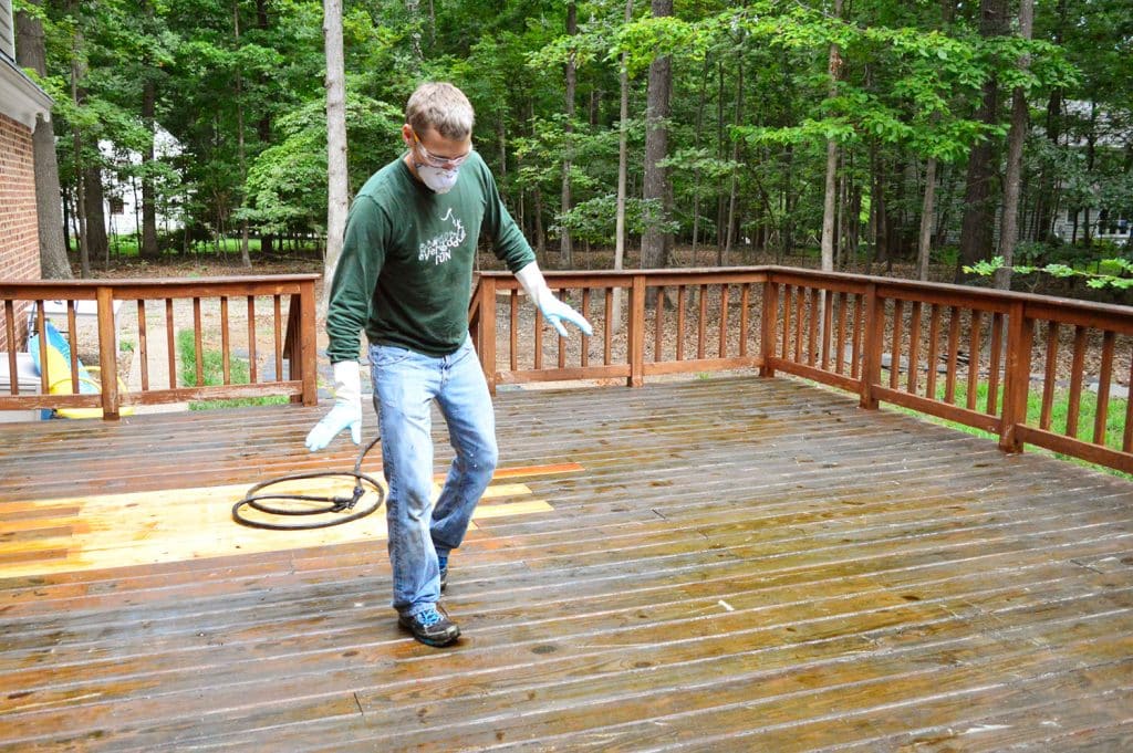 how-to-strip-a-deck-john-walking-carefully-1024x681-1 John tip toeing on wet deck surface