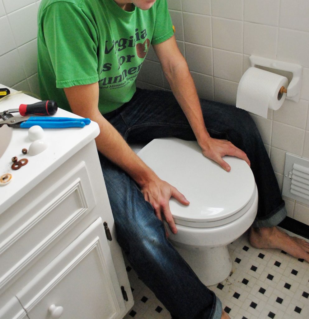 install-a-toilet-weight-on-bowl-993x1024-1 John Sitting On Back of Toilet Bowl To Press Into Place