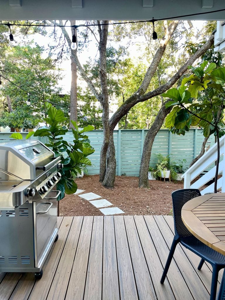 kitchen-porch-vertical-looking-out-wide-768x1024-1 Vertical view from cover patio with grill and table overlooking greenery in yard