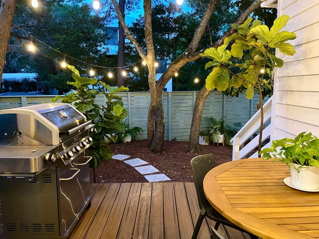 kitchen-porch-wide-shot-at-night-from-door-1024x768-1 View looking out from kitchen porch with string lights glowing above grill and table for eating