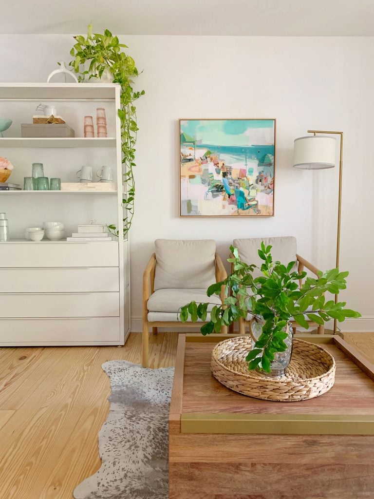 loveseat-bookshelf-and-chairs-vertical-shot-768x1024-1 Side view of sitting area with plants on coffee table and hanging from kitchen shelf
