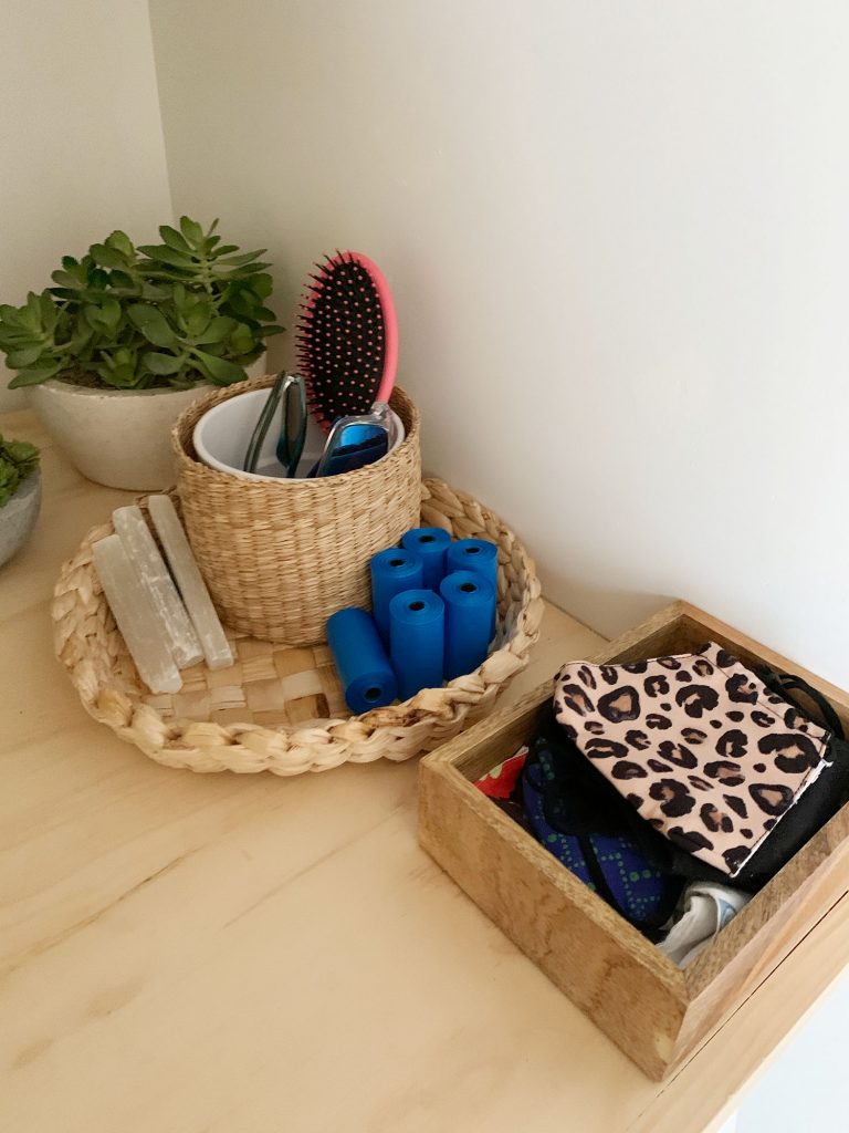 loveseat-laundry-room-storage-closeup-768x1024-1 Baskets and bins on laundry shelf holding entryway accessories like masks dog bags and sunglasses