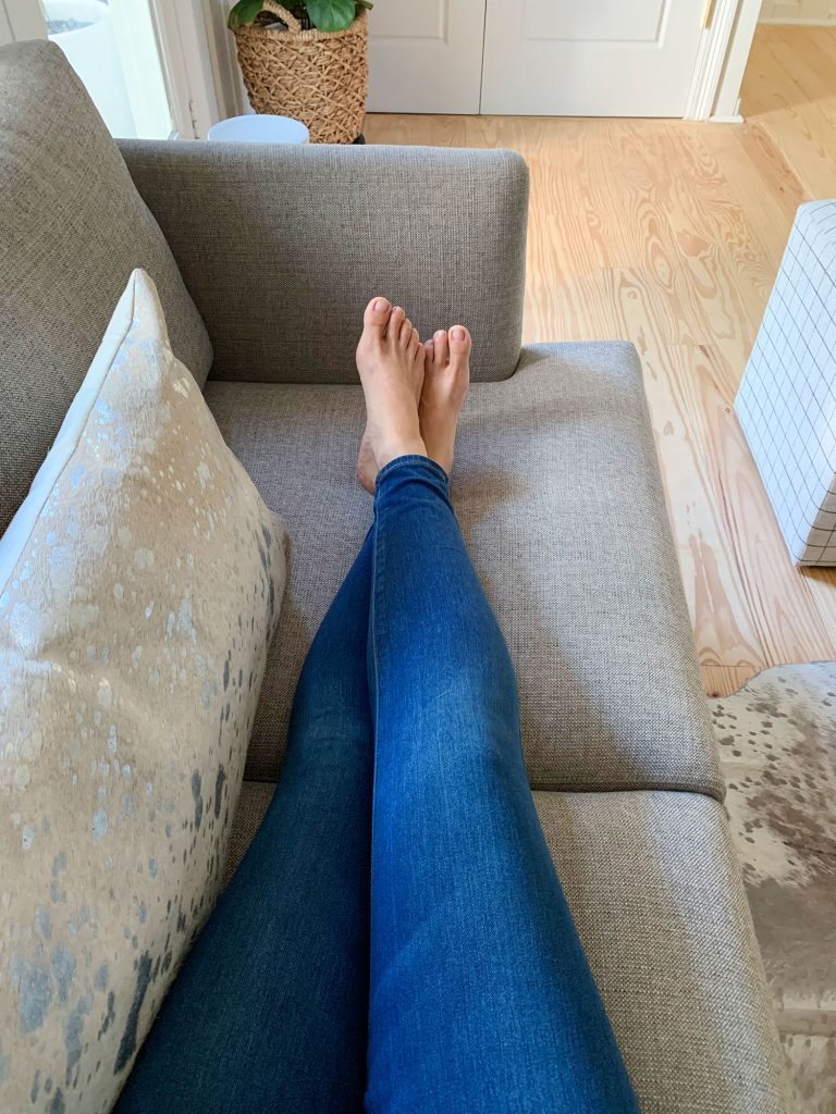 loveseat-legs-out-768x1024-1 Sherry's legs stretched out on gray loveseat