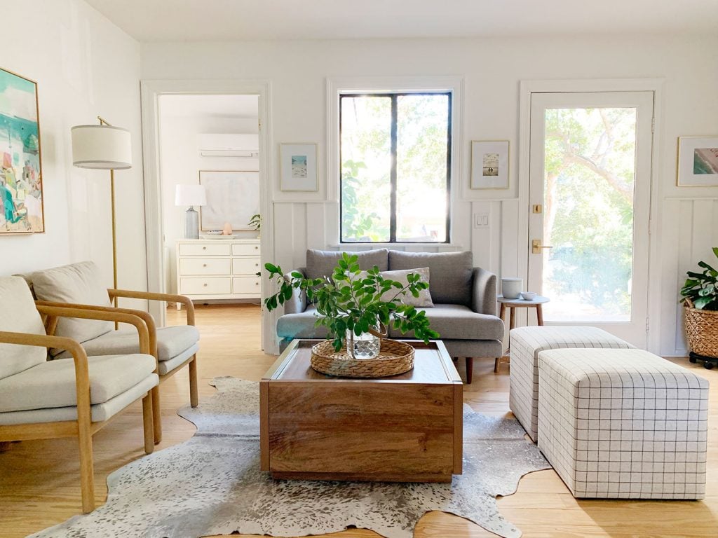 loveseat-sitting-area-towards-window-horizontal-1024x768-1 Sitting area including wood coffee table two plaid ottomans two arm chairs and gray loveseat