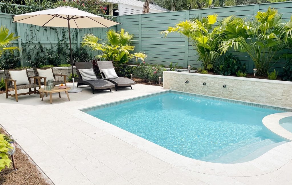pool-post-after-looking-at-fence-corner-1024x651-1 Small freeform pool enclosed by green fences with DiamondBrite Ivory plaster and shellstone travertine