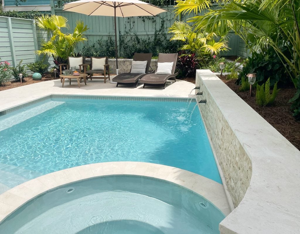pool-post-after-towards-fence-along-retaining-wall-1024x800-1 View of curved tile accent retaining wall covered in stone with fountains into pool