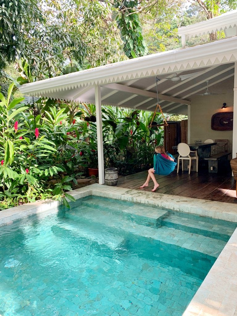 pool-post-costa-rica-pool-lush-landscape-768x1024-1 Inspiration photo of small tropical pool next to white house and child in swing