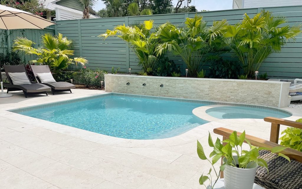 pool-post-horizontal-retaining-wall-palms-1024x643-1 Small backyard pool with curved edge and fan palm plants behind retaining wall