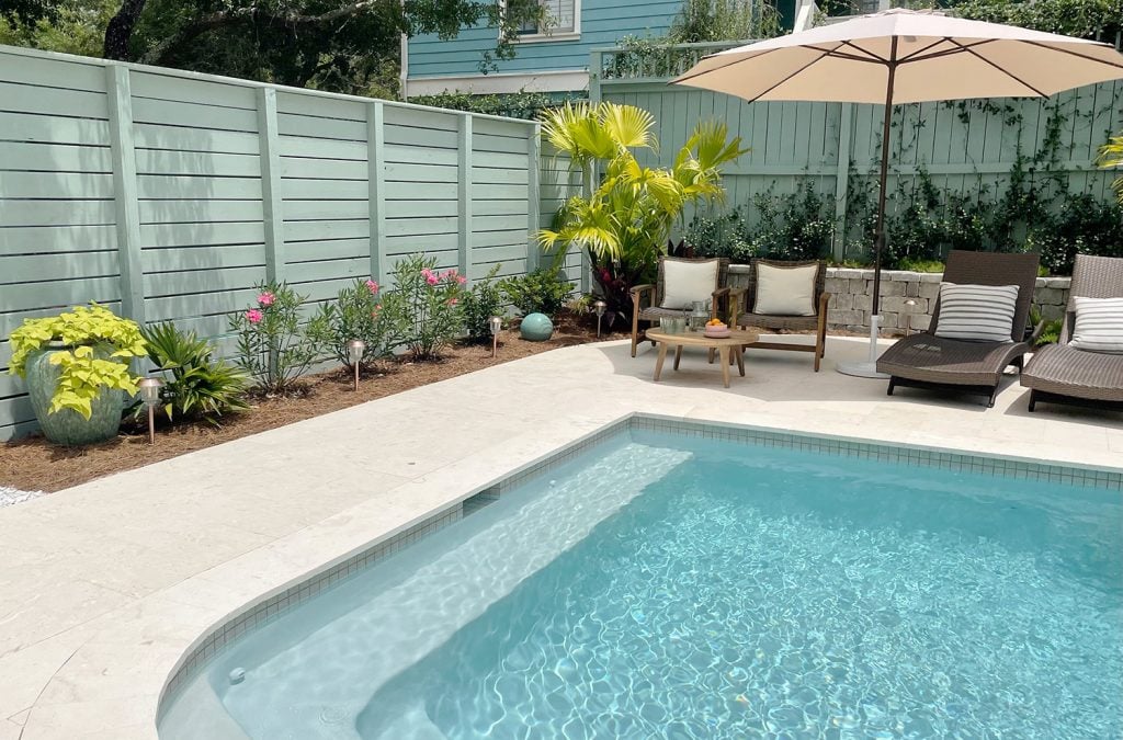 pool-post-side-of-fence-and-corner-with-palm-1024x675-1 Two gray green painted wood fences surrounding pool at different heights